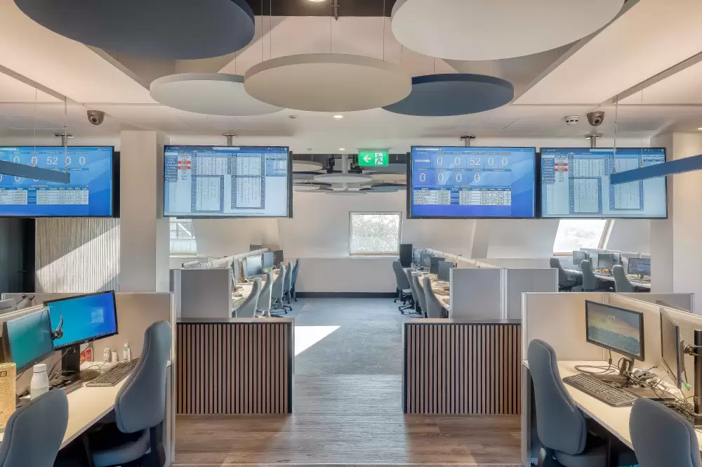 Photo of call centre open plan office space with bright contemporary lighting and modern workstations