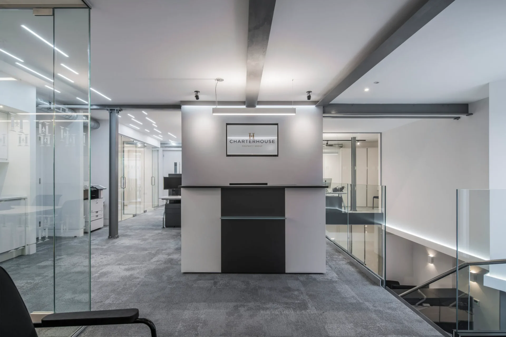 Photo of charterhouse office interior with contemporary lighting design and minimalist workspace layout