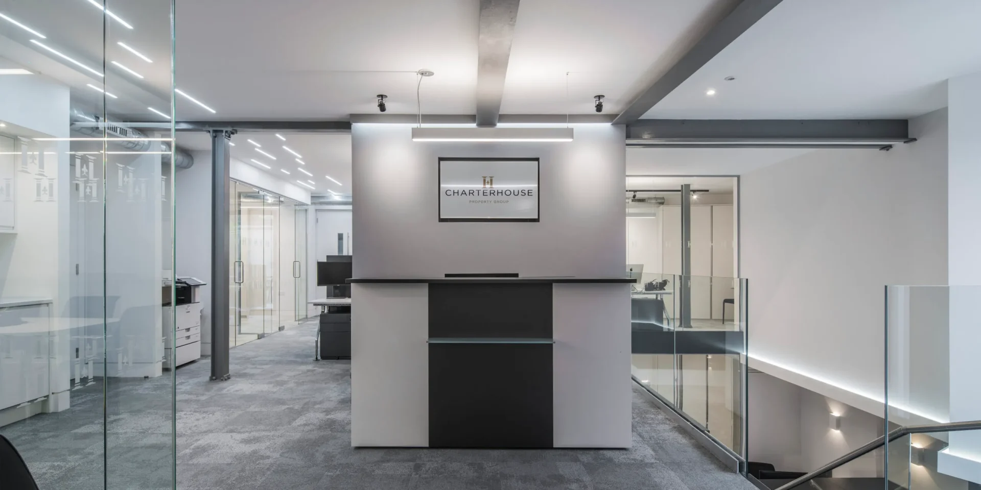 Photo of charterhouse office interior with contemporary lighting design and minimalist workspace layout