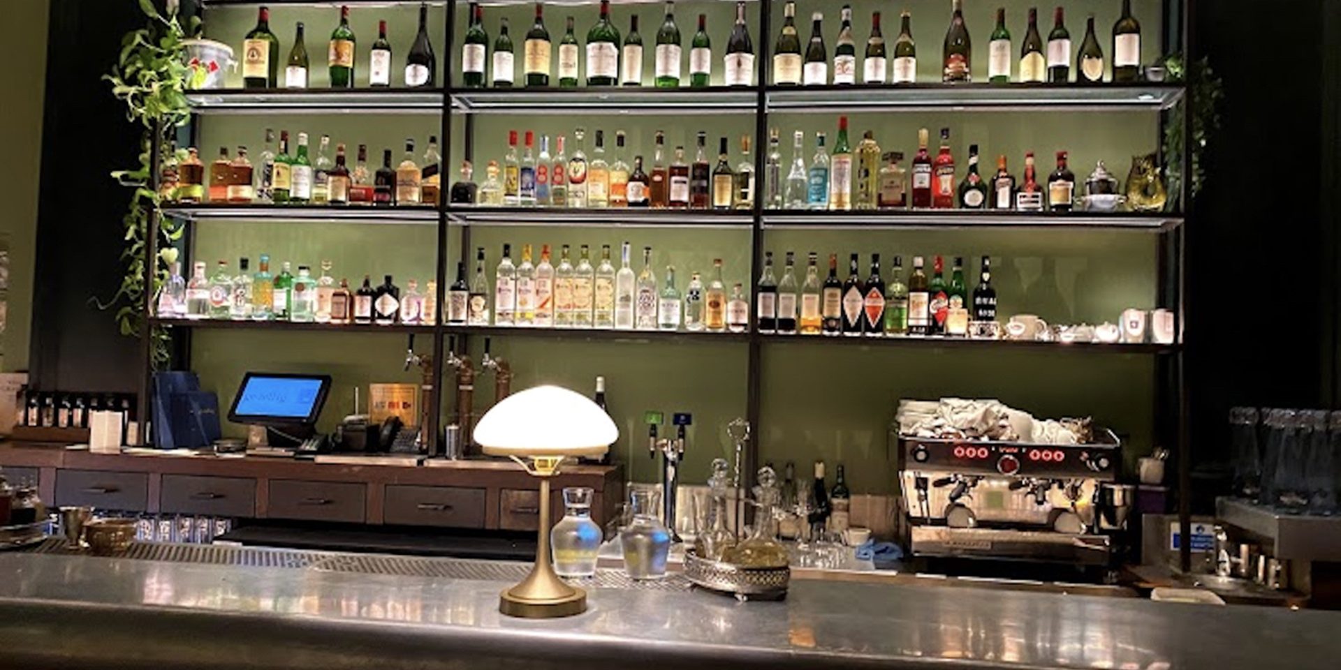 Photo of gezellig historic restaurant interior with illuminated shelving displays and ambient bar lighting