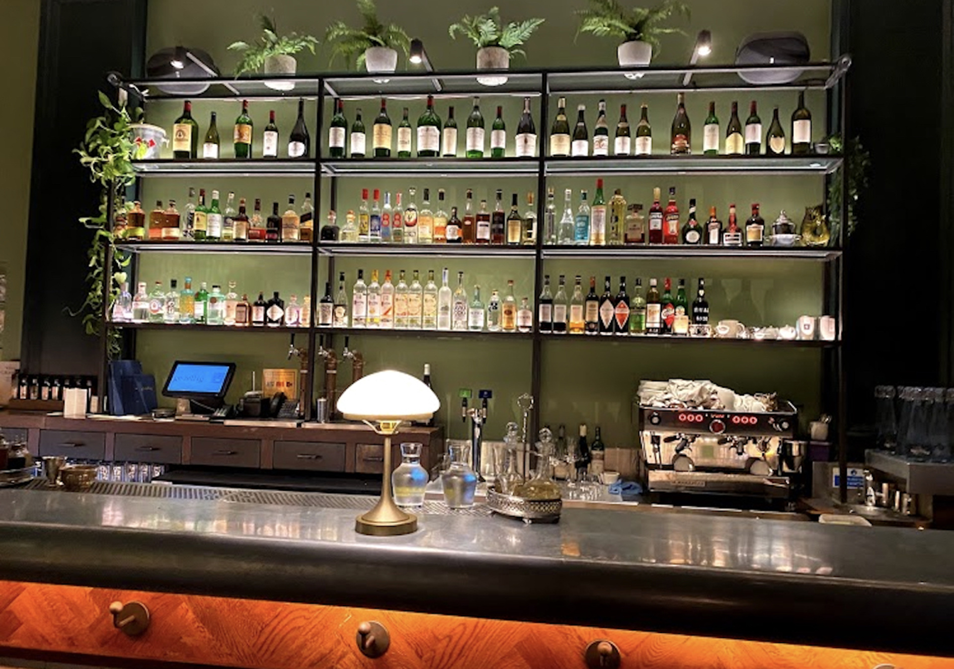 Photo of gezellig historic restaurant interior with illuminated shelving displays and ambient bar lighting