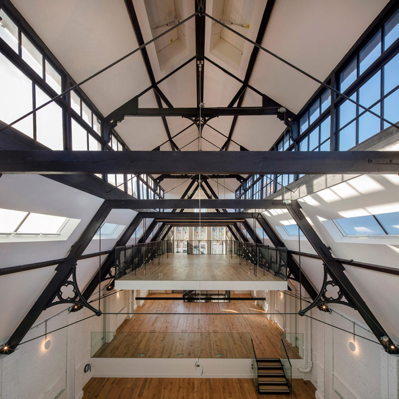 Photo of iffley road coworking space with industrial timber beams, natural windows and contemporary lighting design