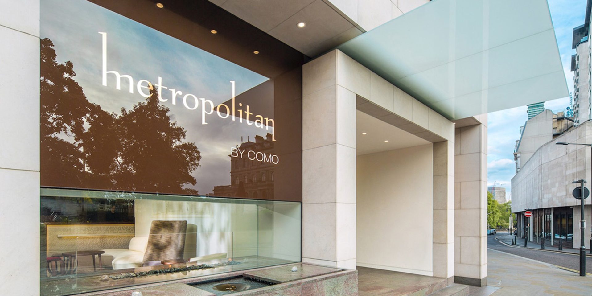 Photo of metropolitan hotel entrance with contemporary glass architecture and modern ambient lighting