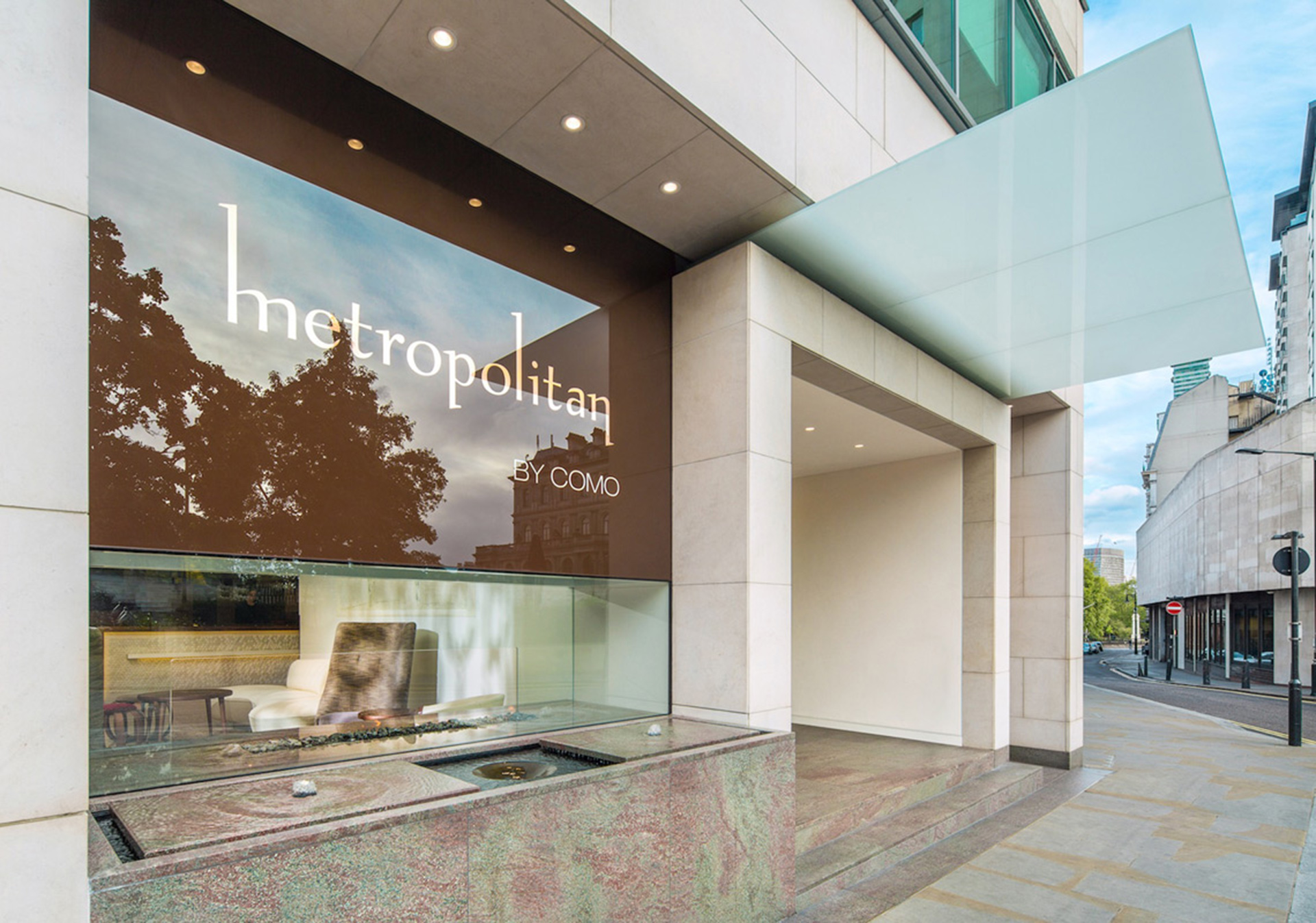 Photo of metropolitan hotel entrance with contemporary glass architecture and modern ambient lighting
