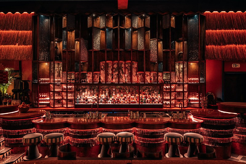 Architectural lighting supply for a luxury bar interior, featuring layered ceiling fittings and illuminated shelving requiring careful specification and lead time management